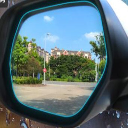 Car side mirror reflecting a street scene with trees and buildings.