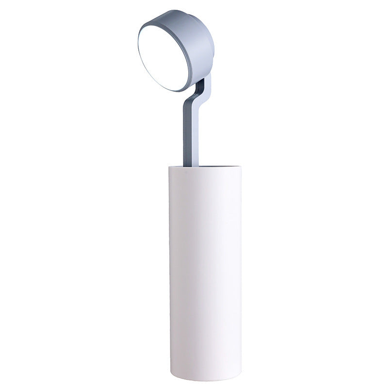 Modern floor lamp with a cylindrical base and round adjustable head on a white background