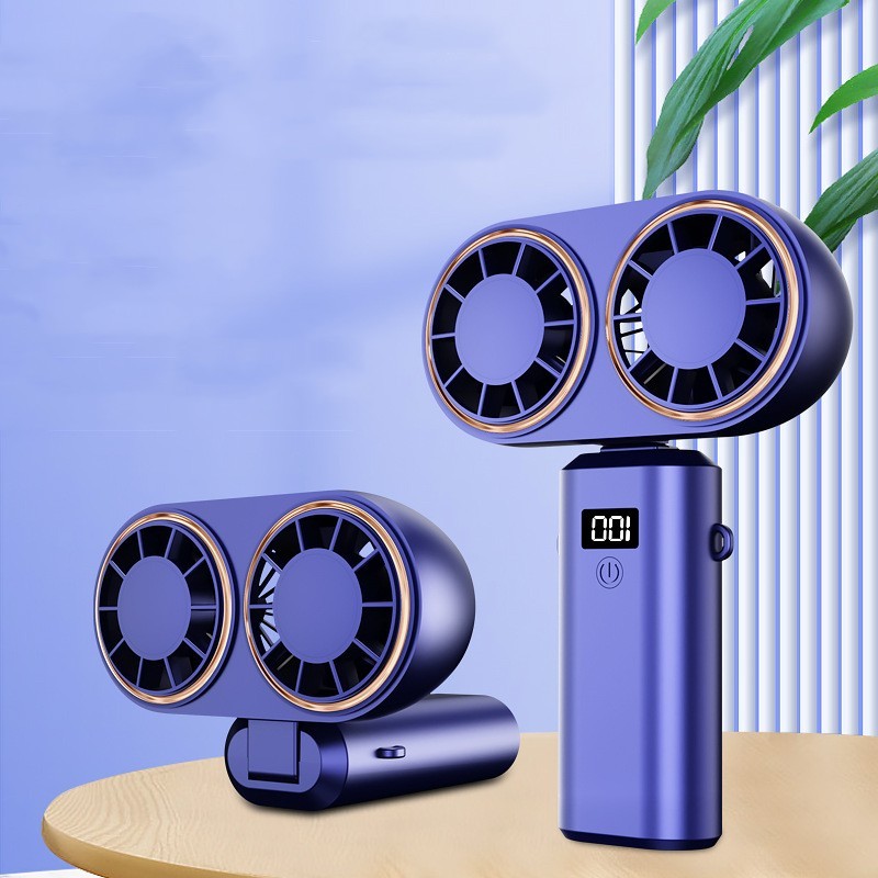 Purple handheld fan with dual fans on a wooden surface against a light blue background