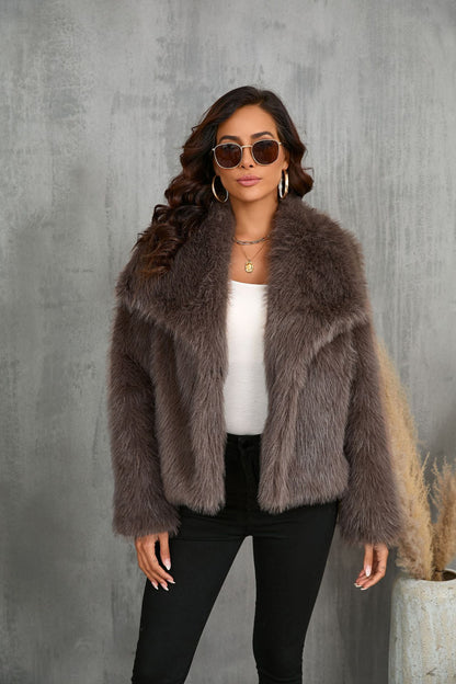 Woman wearing a fur coat against a gray concrete wall