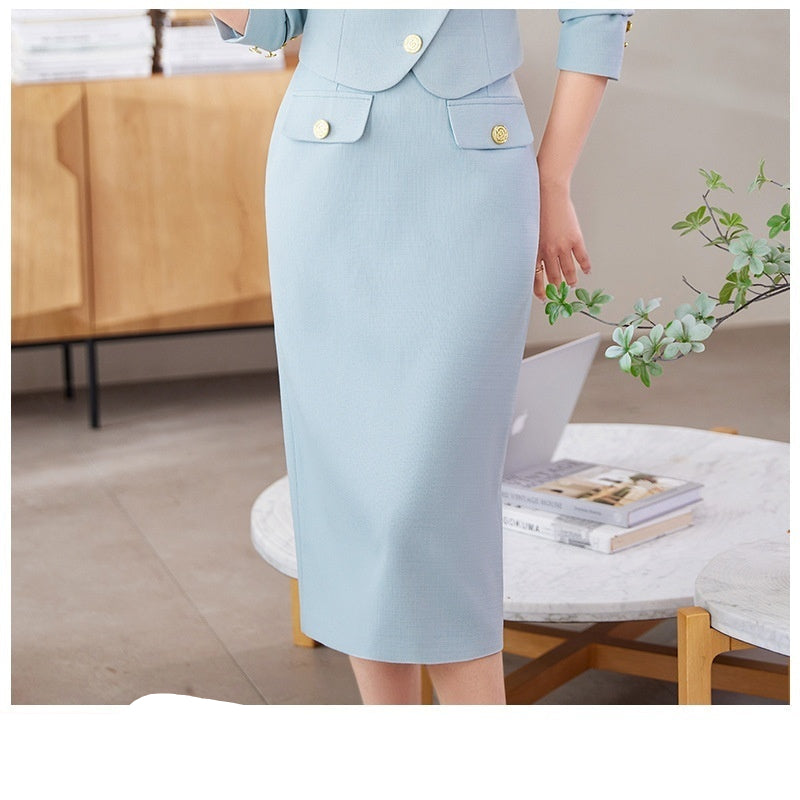 A woman in a white leisure formal suit with a blazer and a skirt, featuring long sleeves and gold buttons, standing outdoors.