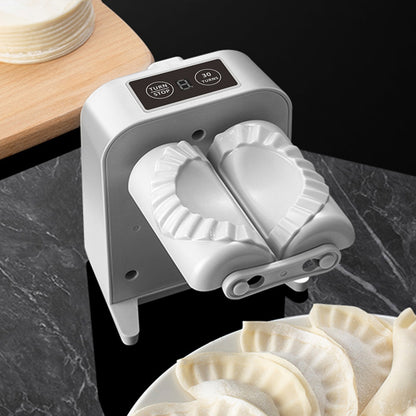 Dumpling maker on a dark surface with dumplings nearby