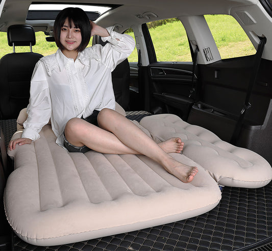 Person sitting on an inflatable car mattress in a vehicle