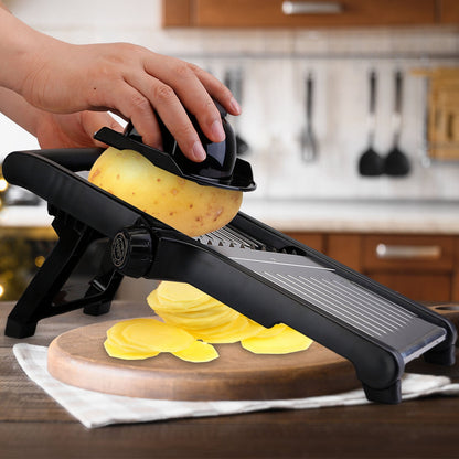 Person using a mandoline slicer to cut potatoes in a kitchen setting.