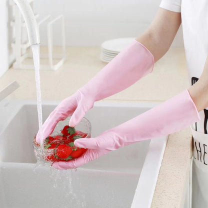 Person washing strawberries in a sink with pink gloves on