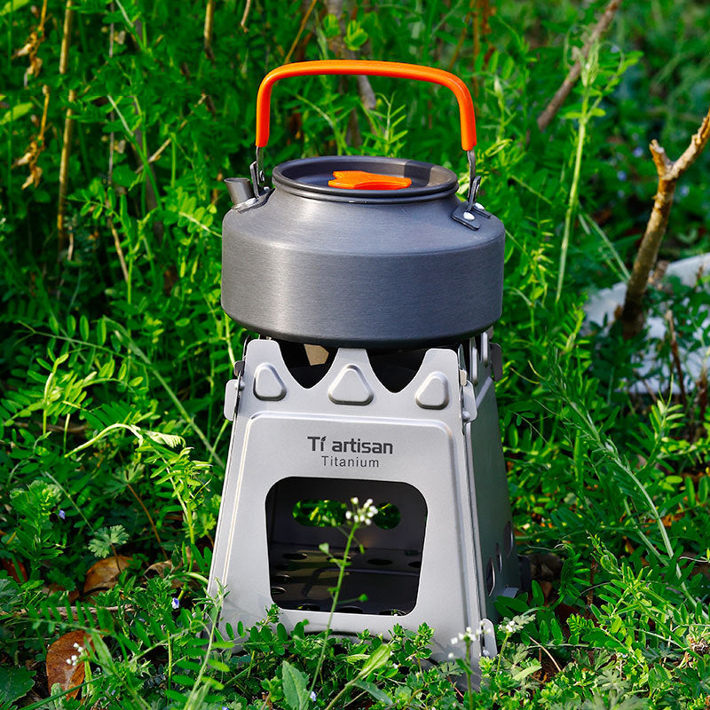 Camping stove with orange handle on grass