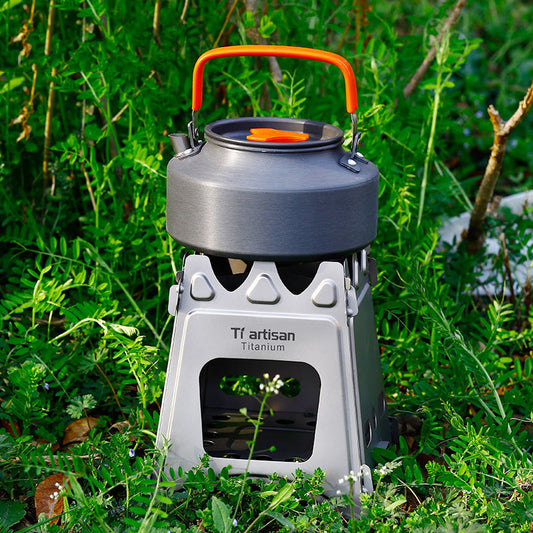 Camping stove with orange handle on grass
