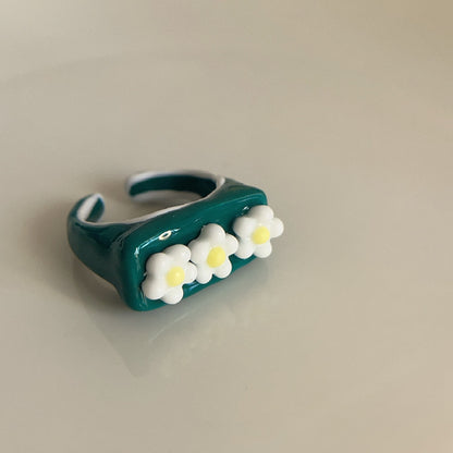 Teal ring with white flowers on a beige background