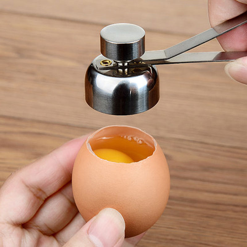 Egg shell being cracked open with a tool on a wooden surface