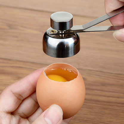 Egg shell being cracked open with a tool on a wooden surface