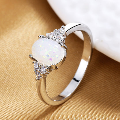 Silver ring with a white gemstone on a beige fabric background