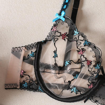 Black lace bra with floral embroidery on a beige background