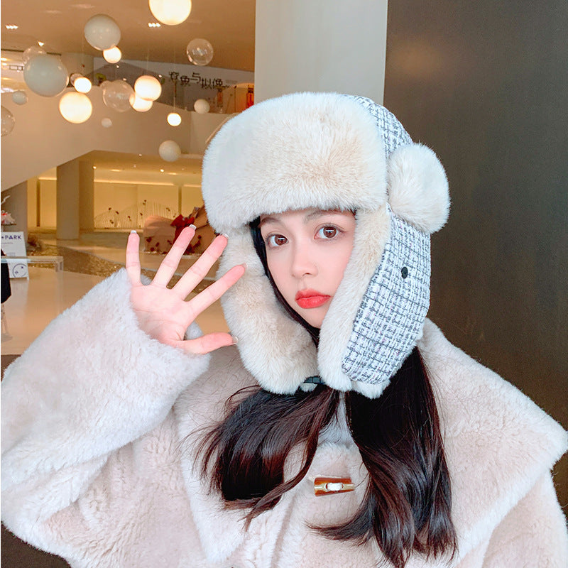 Person wearing a fluffy white hat with ear flaps in an indoor setting