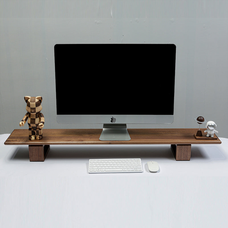 Wooden desk monitor stand with a computer monitor, keyboard, and decorative figures.