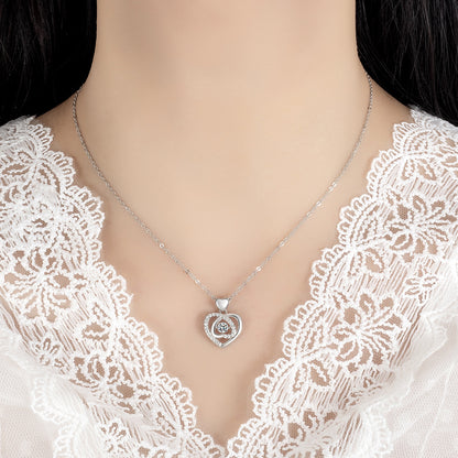 Mannequin wearing a silver necklace with a heart-shaped pendant on a white lace garment.