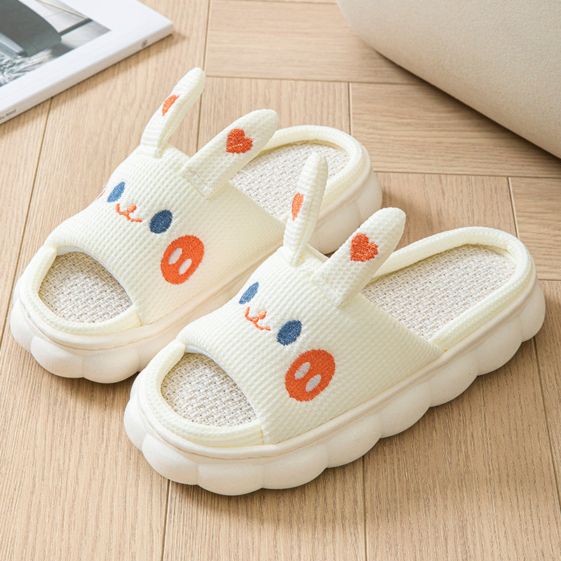 Pair of white slippers with colorful designs on a wooden floor.
