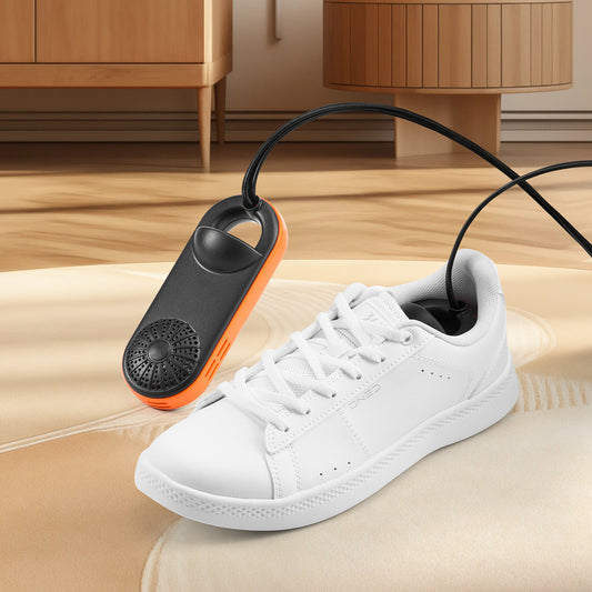 White sneaker with a black and orange shoe dryer on a wooden floor.
