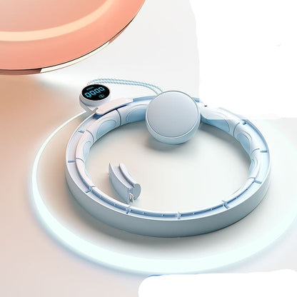 White weightlifting ring with digital display on a light pink background