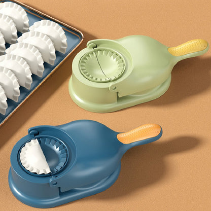 Two dough cutters, one green and one blue, on a brown surface with a tray of white dumplings.
