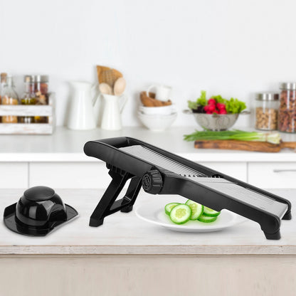Black mandoline slicer on a kitchen counter with sliced cucumbers